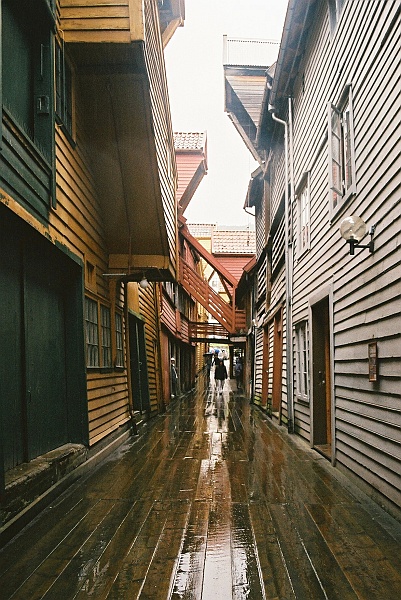 F1040025.JPG - Wąskie uliczki pomiędzy domkami, wyłożone deskami. Pada, czyli potwierdzenie -- jesteśmy naprawdę w Bergen. (Zdjęcie - Rafał).